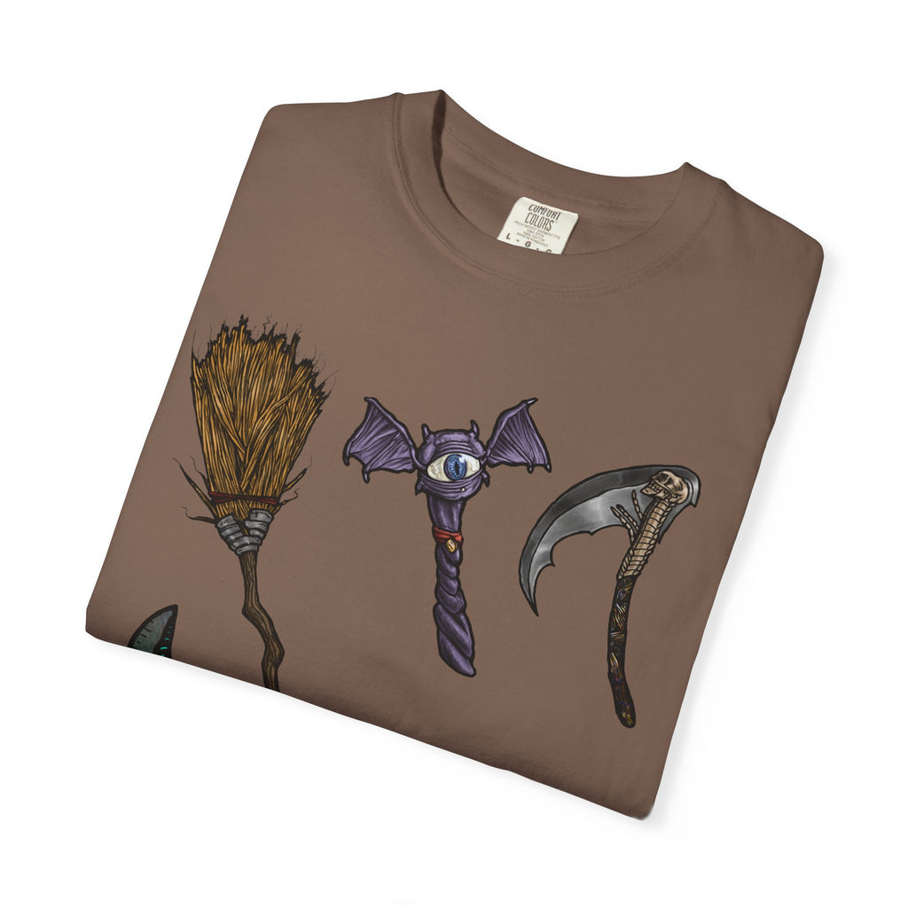 Hand-drawn Item Selection #1 t-shirt from Freaky Features showing a collection of monster weapons: broom, bat staff, skeletal scythe, shark dagger, ice cream cone and war hammer on dark gray tee
