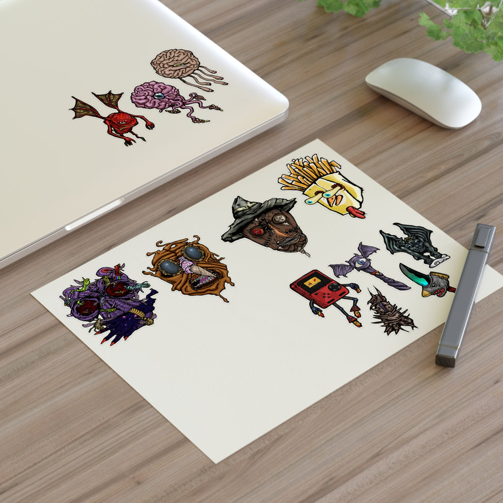 Freaky Features Sticker Sheet Set #3 , transparent die-cut sheet with 12 hand-drawn monsters and creatures including alien swarm, melting chocolate head, scarecrow, french fry box, walking Game Boy ( Gamerpal) , brains, and various weird weapons/creatures

