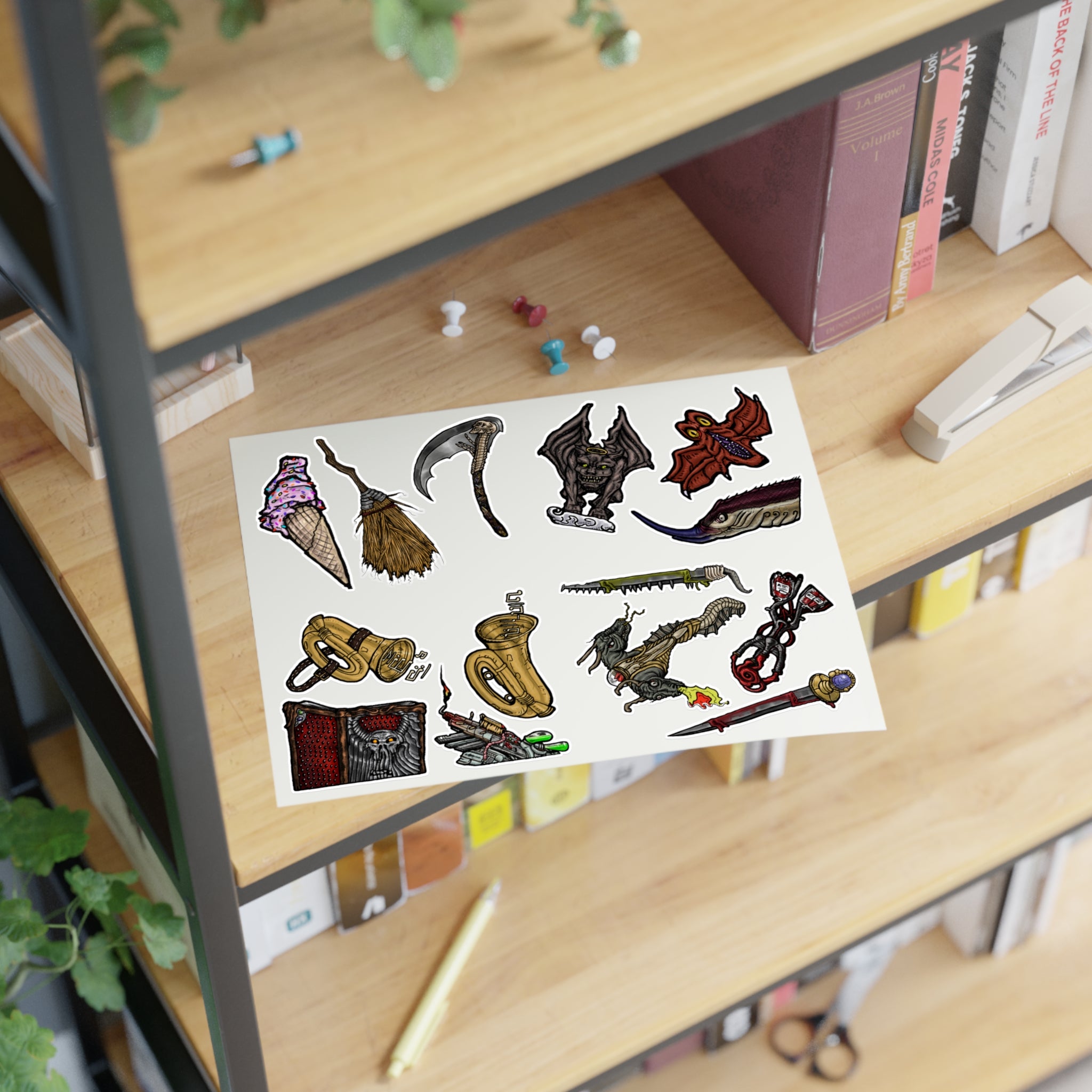 Freaky Features Sticker Sheet Set #4, transparent die-cut sheet with 14 hand-drawn weapons and creatures including ice cream cone, witch broom, skeletal scythe, bat-winged hellbeast, cursed tome and more
