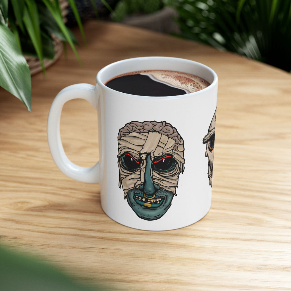 Freaky Features Mummy Chicken Mushroom mug showing three monster designs: bandaged mummy with exposed brain, paranoid rooster with sunglasses, and multi-eyed mushroom skull on white ceramic mug

