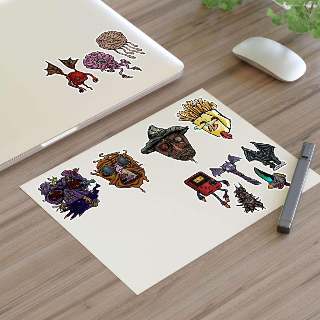 Freaky Features Sticker Sheet Set #3 , transparent die-cut sheet with 12 hand-drawn monsters and creatures including alien swarm, melting chocolate head, scarecrow, french fry box, walking Game Boy ( Gamerpal) , brains, and various weird weapons/creatures
