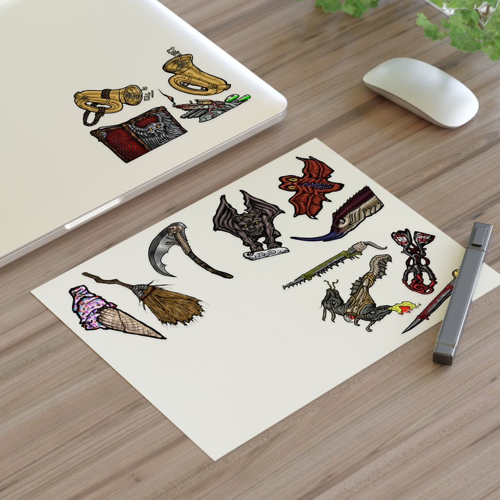 Freaky Features Sticker Sheet Set #4, transparent die-cut sheet with 14 hand-drawn weapons and creatures including ice cream cone, witch broom, skeletal scythe, bat-winged hellbeast, cursed tome and more
